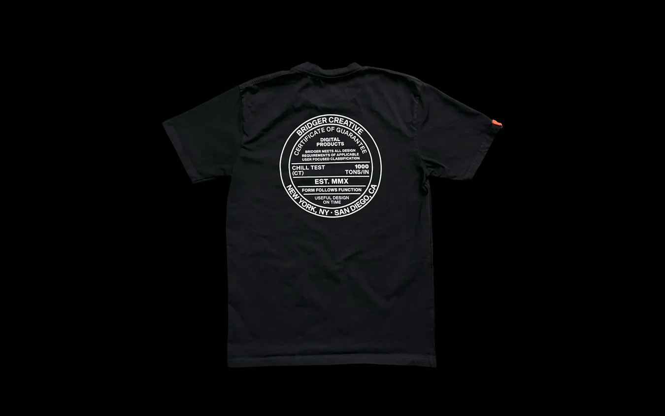 Back of a black t-shirt on black printed with a large white circular seal