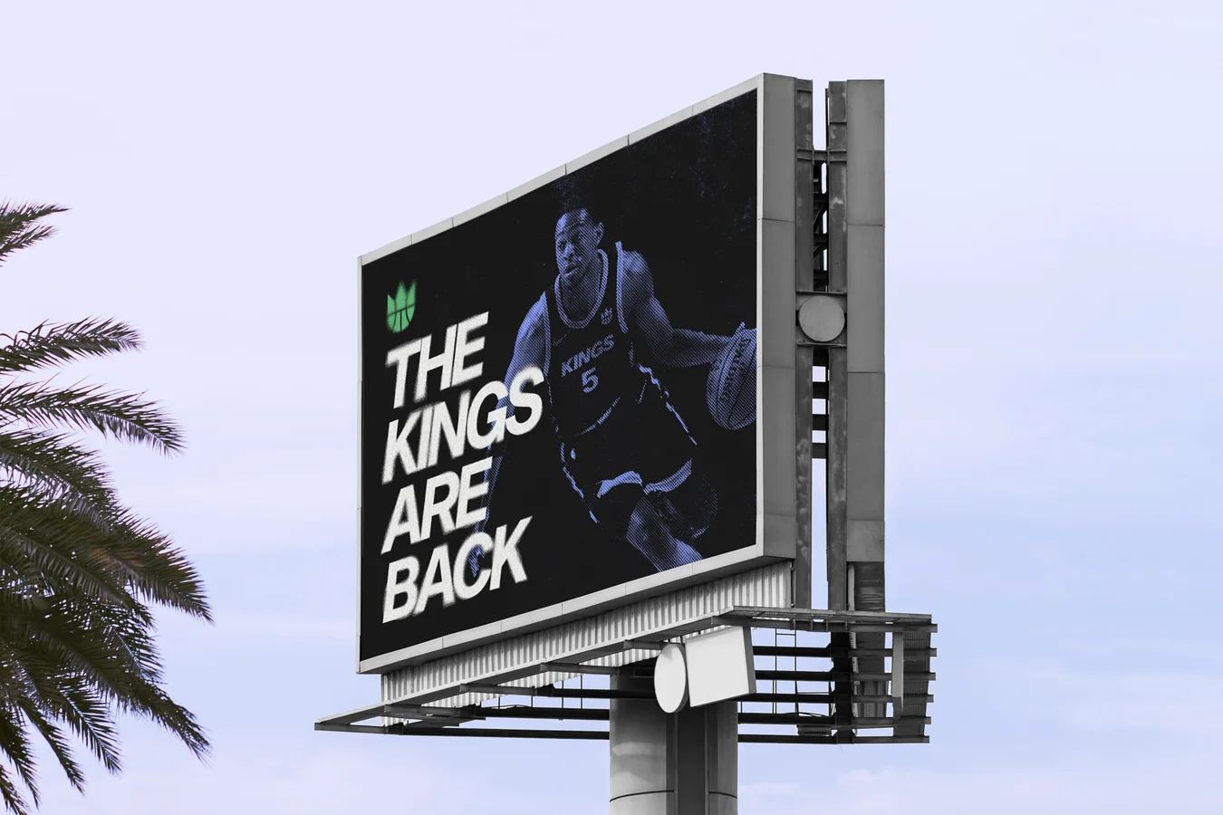 Billboard against a pale sky reading THE KINGS ARE BACK beside a blue-toned basketball player in a number 5 jersey, with a palm frond at left