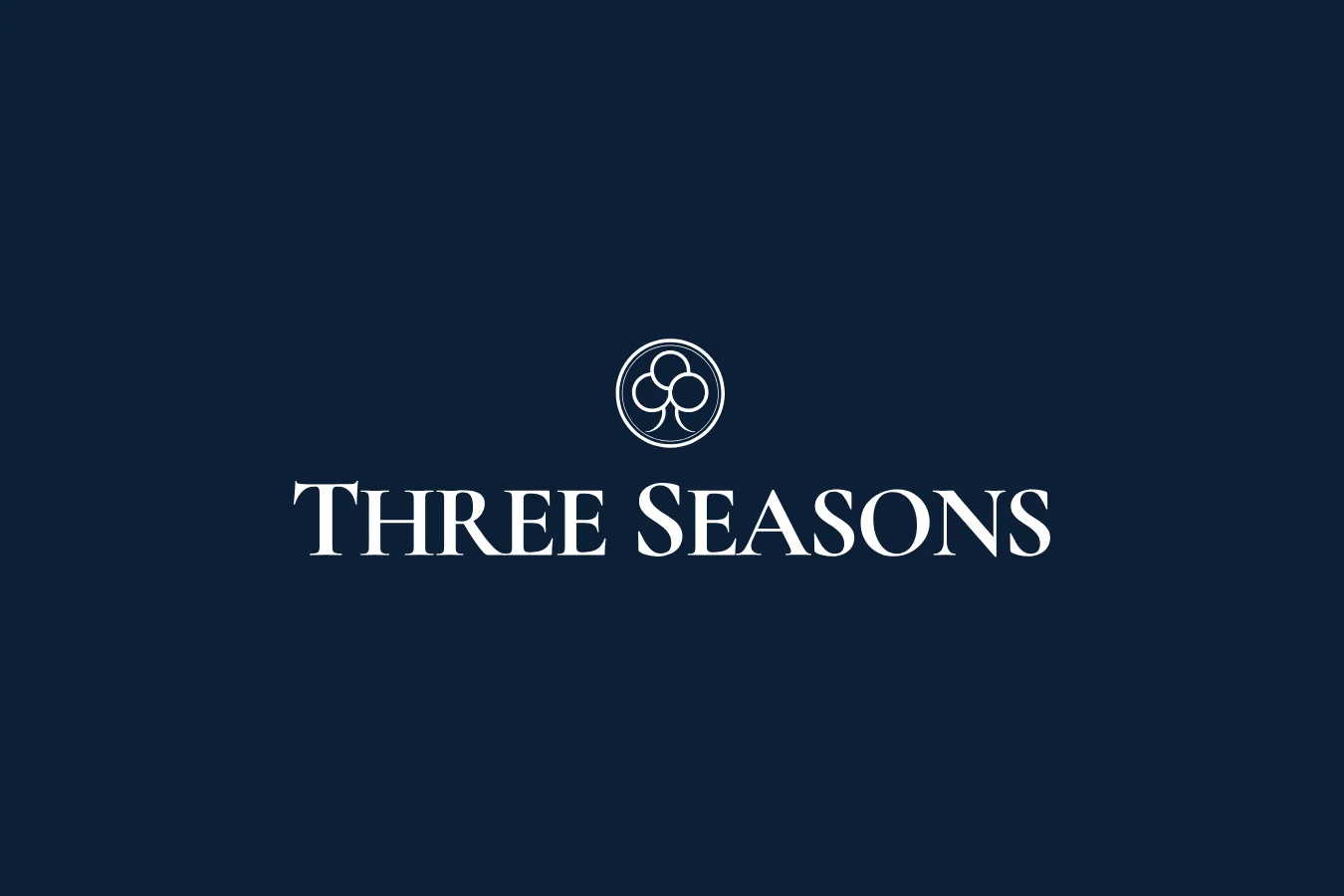 Three Seasons wordmark and tree mark in white on navy